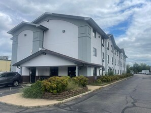 A modern multi-story building with a flat roof, large windows, and a covered entrance area. - Super 8 by Wyndham Danville VA (Danville)