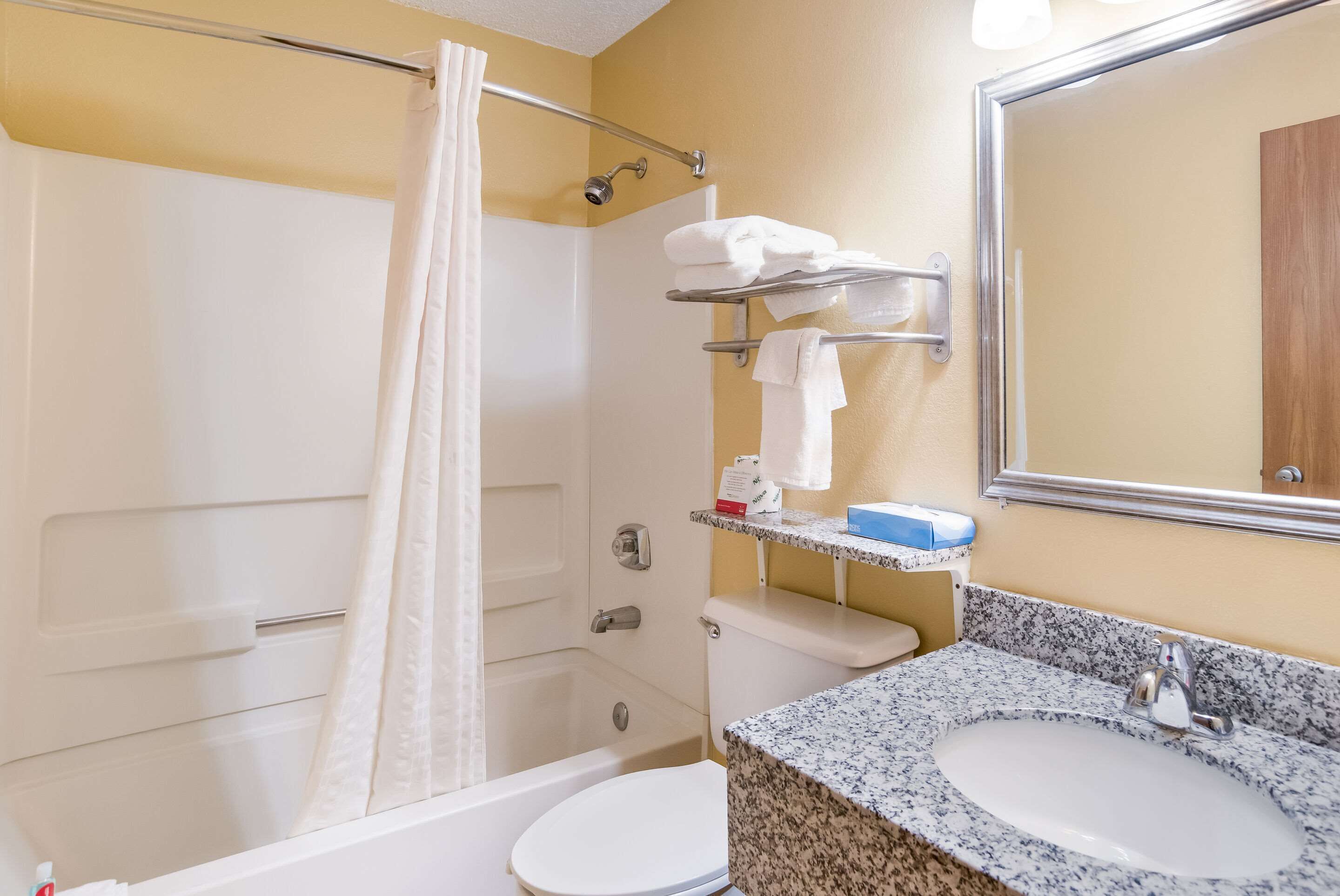 A bathroom with a bathtub, toilet, sink, and a towel rack.