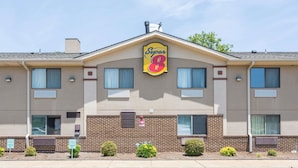 A Super 8 hotel with a brick facade, multiple windows, and a clear blue sky. - Super 8 by Wyndham Hampton (Hampton)