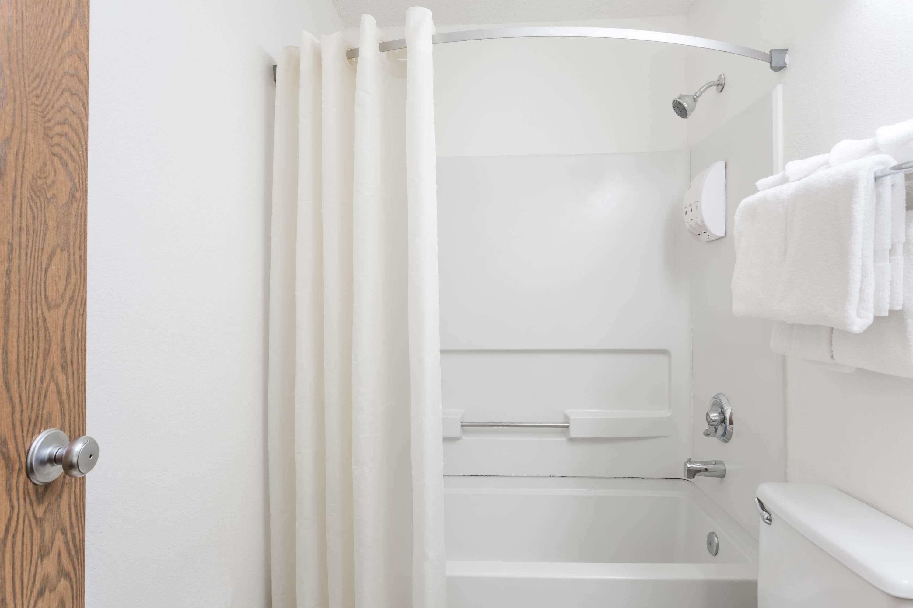 A modern bathroom with a shower, toilet, and towel rack.