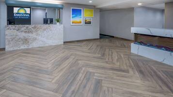 A reception area with a marble counter, a reception desk, and framed pictures on the wall.
