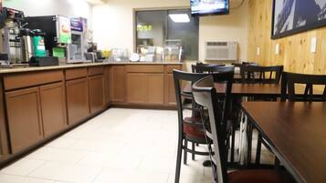 A restaurant interior with a counter, chairs, and a television mounted on the wall.
