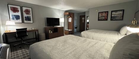 Espacio para trabajar con laptop y tabla de planchar con plancha