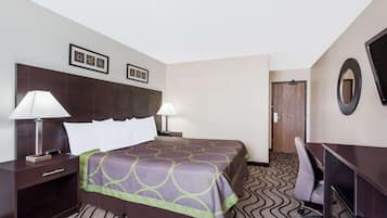 A hotel room with a bed, two bedside lamps, a desk, a chair, and a TV.