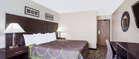 A hotel room with a bed, two bedside lamps, a desk, a chair, and a TV.