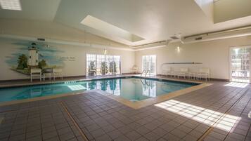 Una piscina techada, sillones reclinables de piscina