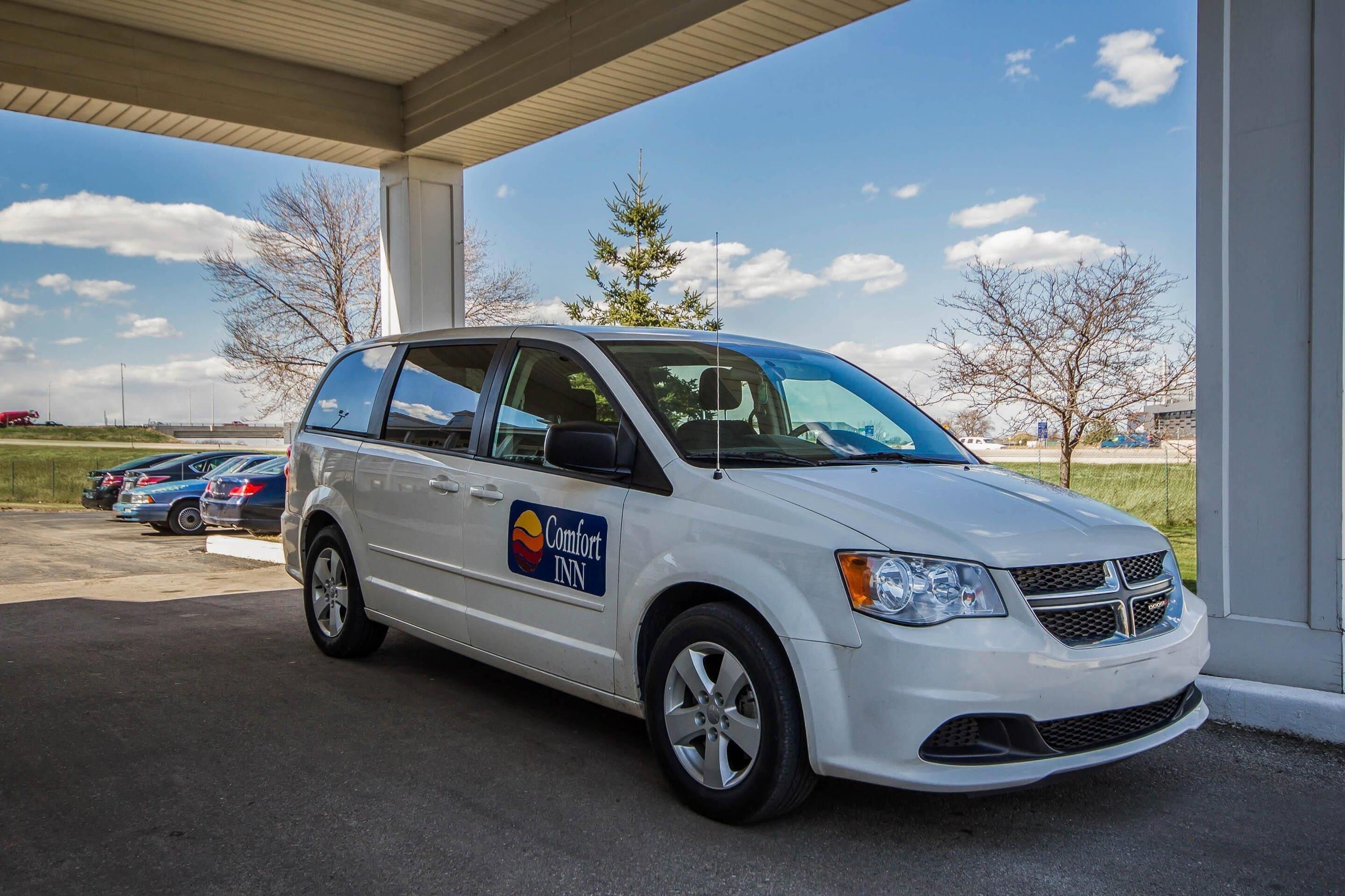 A white van with 'Comfort Inn' branding parked under a covered area.