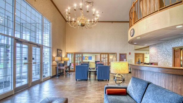 A spacious lobby with a chandelier, seating area, reception desk, and large windows. - Comfort Inn Fond Du Lac (Fond du Lac)