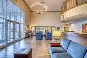 A spacious lobby with a chandelier, seating area, reception desk, and large windows. - Comfort Inn Fond Du Lac (Fond du Lac)