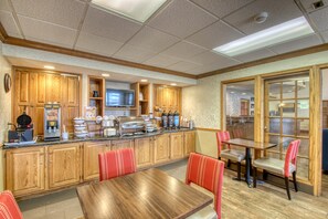A restaurant with wooden cabinets, a buffet area, and red upholstered chairs.