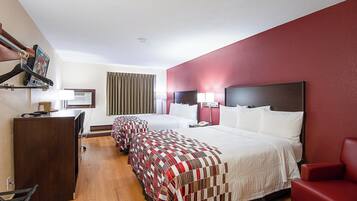 Una habitación de hotel con una cama grande, un escritorio, una silla y un televisor.