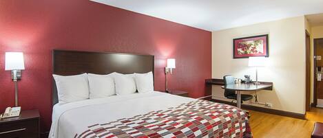 Una habitación de hotel con una cama grande, un escritorio y una silla.
