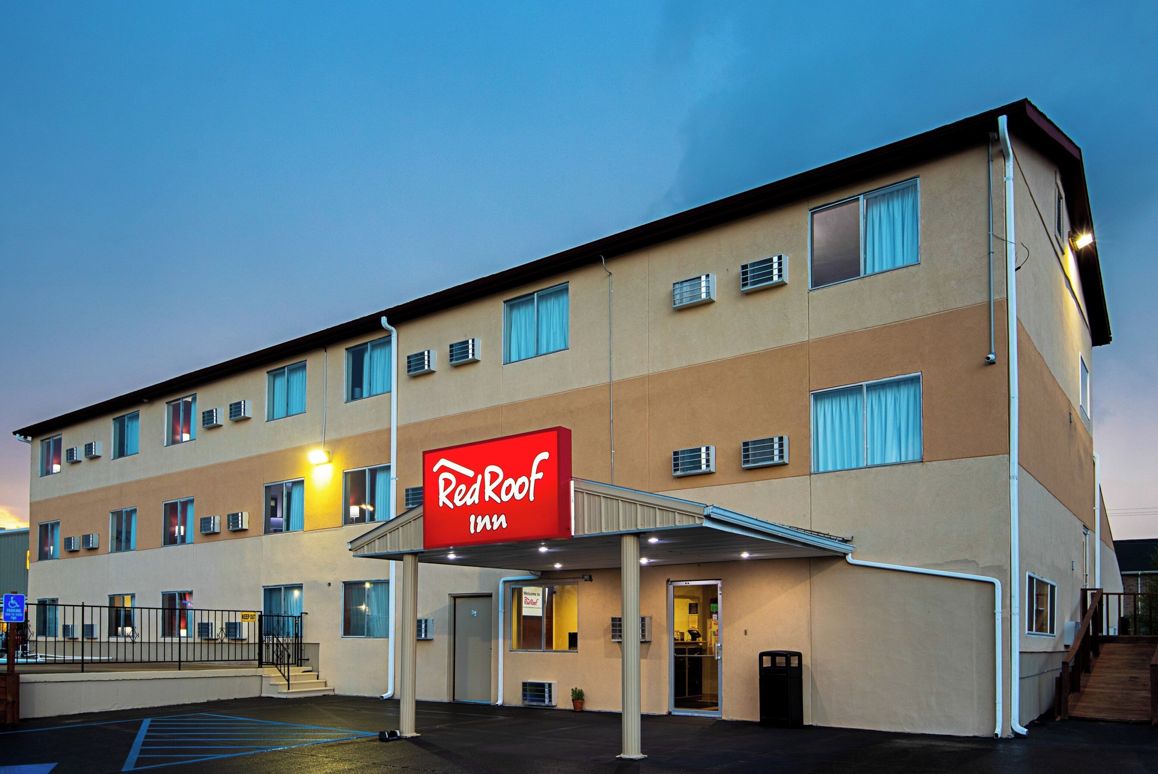 A RedRoof Inn building with a flat facade, multiple windows, and a covered entrance.