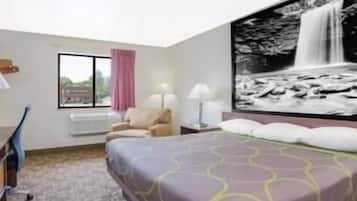 Una habitación de hotel con cama, escritorio, silla, ventana con vistas y un cuadro grande de cascada colgado en la pared.