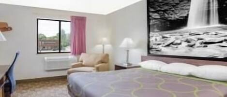 Una habitación de hotel con cama, escritorio, silla, ventana con vistas y un cuadro grande de cascada colgado en la pared.