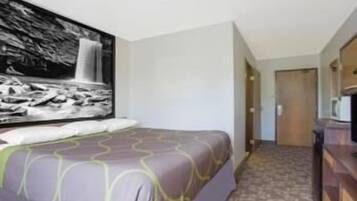A hotel room with a bed, a large wall-mounted artwork of a waterfall, and a patterned carpet.