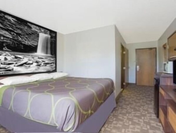 Una habitación de hotel con cama, una gran obra de arte en la pared con motivo de cascada y una alfombra estampada.