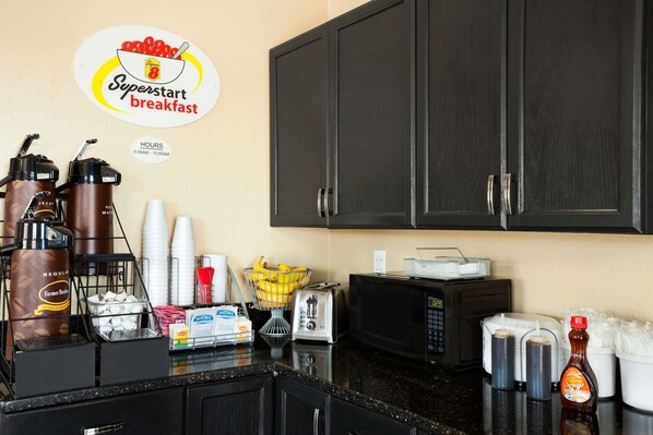 A kitchenette with a coffee maker, toaster, microwave, and various kitchen utensils. - Super 8 by Wyndham Macon (Macon)