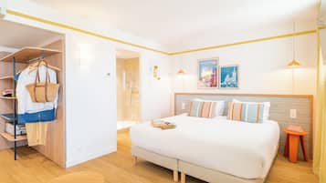 Une chambre d’hôtel moderne équipée d’un lit, d’une armoire et d’une petite table.
