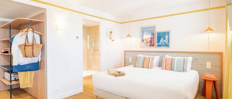 A modern hotel room with a bed, wardrobe, and a small table.