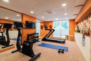 A gym with treadmills, elliptical machines, and free weights. - Hôtel Soléo Prado  (Marseille)