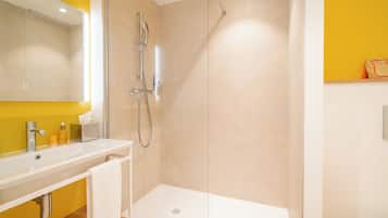 A modern bathroom with a shower, sink, and mirror.