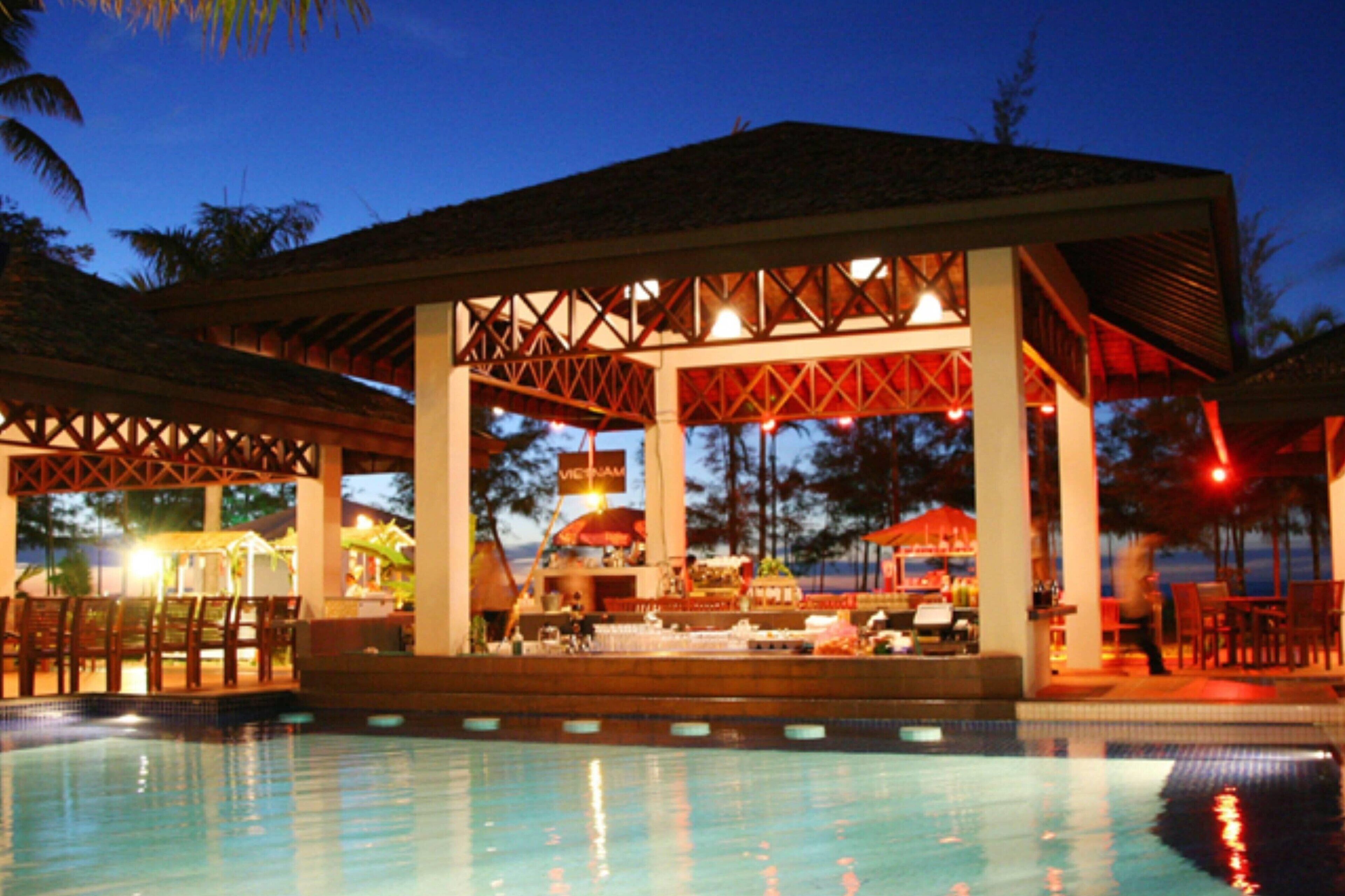A poolside bar area with a covered seating area and a pool.