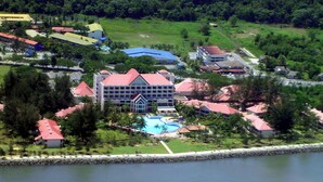 Eine Luftaufnahme eines Resorts mit einem zentralen Gebäude, einem Schwimmbad und umliegender Bepflanzung.