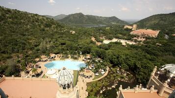 Relax amidst lush greenery and rolling hills, surrounded by a serene pool and a distinctive architectural dome.