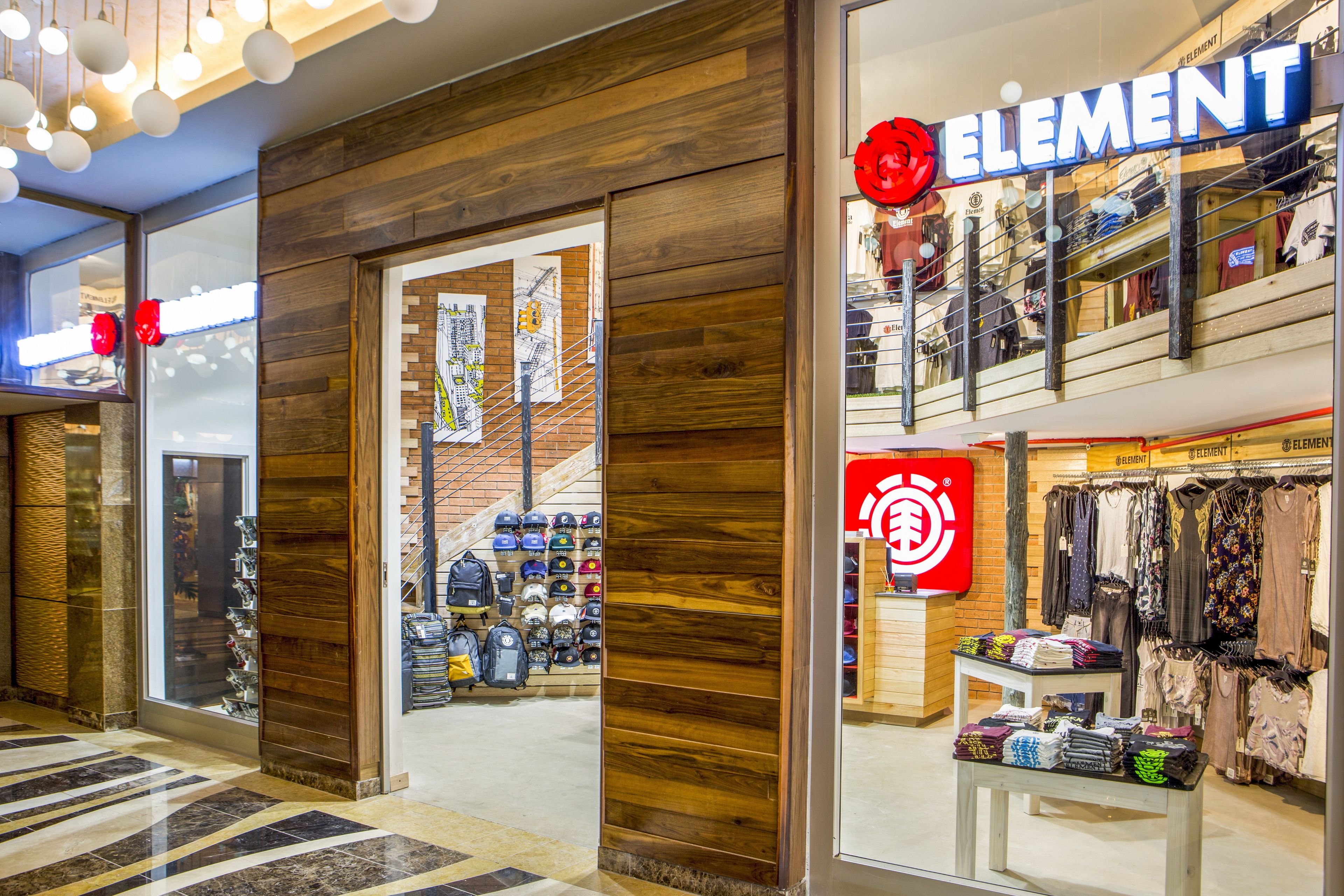 A retail store with wooden paneling and a variety of clothing items on display.