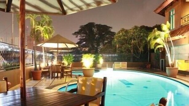 Outdoor pool, pool umbrellas - Travellers Suites Serviced Apartments (Medan)