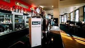 Un espace bar avec un robinet à bière et un panneau indiquant la carte des vins et autres boissons.