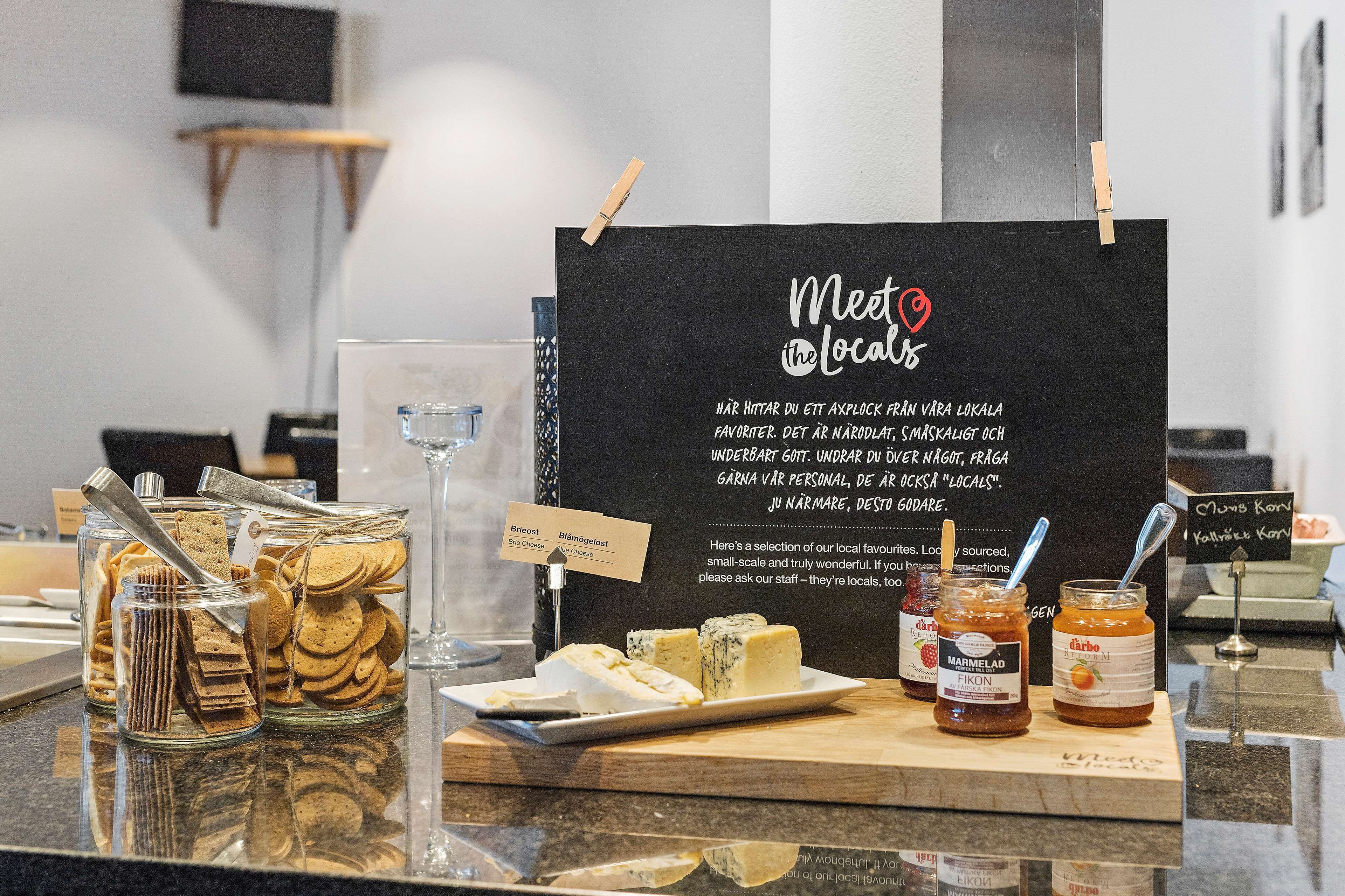 A display of local products including crackers, cheese, and jams with labels indicating their origin.