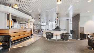Een modern interieur met een bar, zitplaatsen en een hoog plafond met zichtbare balken.