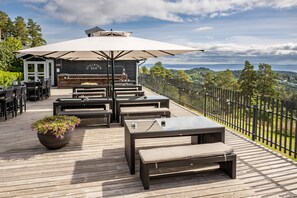 A deck with outdoor seating, a bar, and a view of the landscape. - Quality Hotel Leangkollen (Asker)