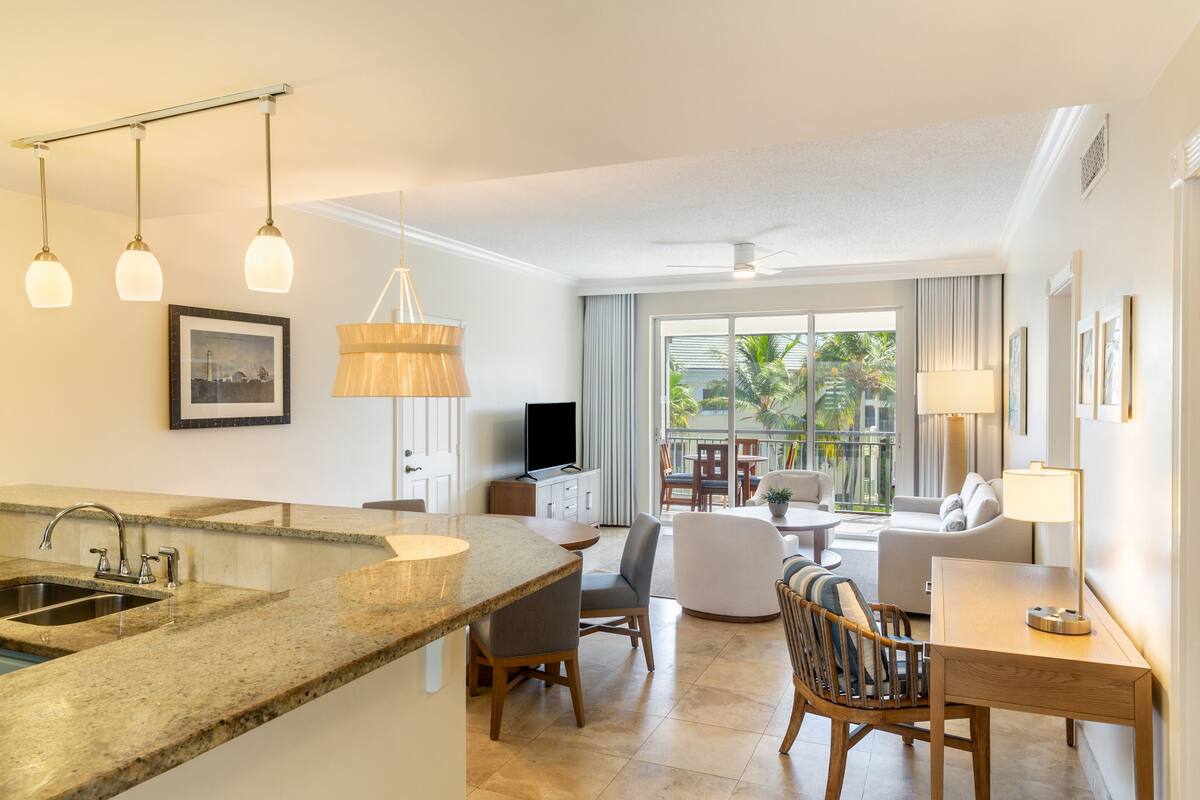 A modern kitchen with granite countertops, a built-in sink, and pendant lighting.