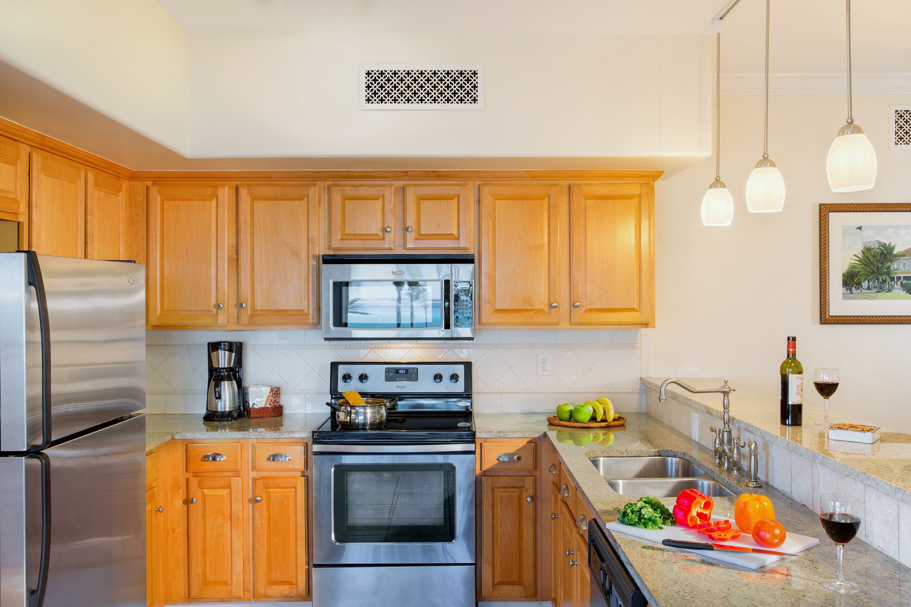 A modern kitchen with stainless steel appliances, wooden cabinets, and a granite countertop.