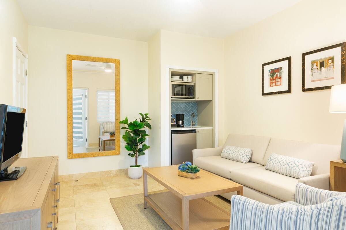 A modern living room with a sofa, coffee table, and a TV on a wooden cabinet.