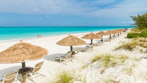 På stranden, hvit sand, strandtelt (inkludert) og solsenger