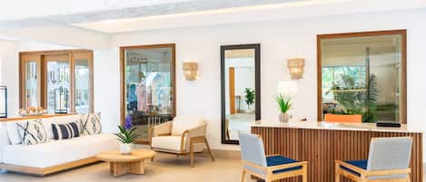 Un moderno vestíbulo de hotel con una recepción, zona de estar y ventanas amplias.