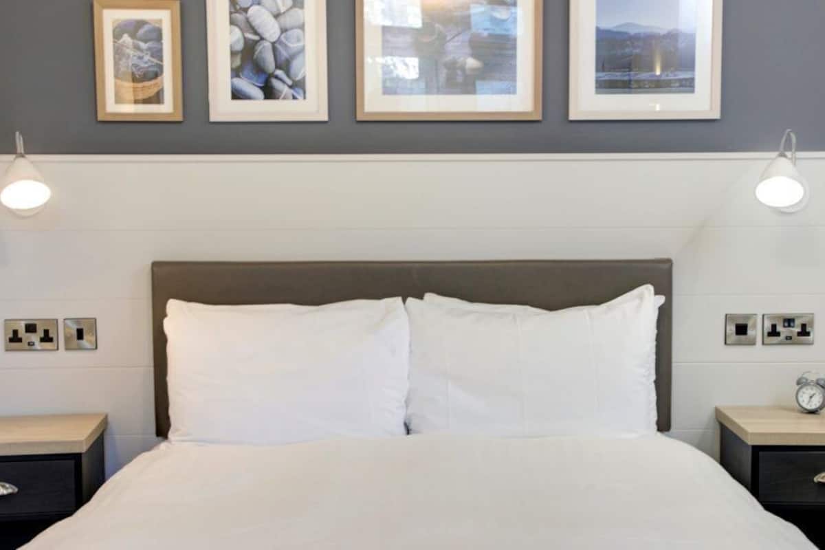 Escritorio, cortinas blackout y tabla de planchar con plancha