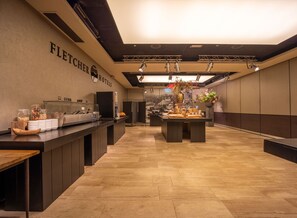 A hotel kitchen with a long counter, various food items, and a sign that reads 'Fletcher Hotels'. - Fletcher Hotel-Restaurant De Korenbeurs (Made)