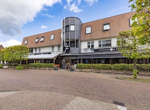 A hotel with a modern design, featuring a prominent curved structure and a sign for 'Fletcher Hotels'. - Fletcher Hotel-Restaurant De Korenbeurs (Made)