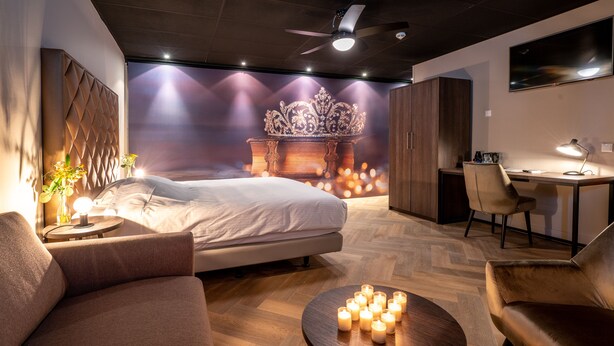 Une chambre moderne comprenant un lit, un bureau et un coin salon avec une table basse.