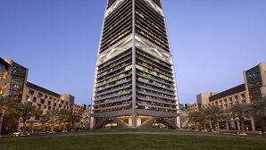 A modern skyscraper with a distinctive triangular top, surrounded by well-maintained lawns and palm trees. - Mandarin Oriental Al Faisaliah, Riyadh (Riyadh)