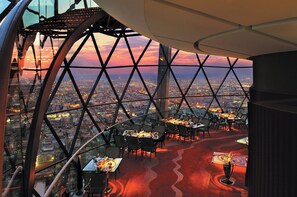 A restaurant with a panoramic city view, featuring a unique geometric glass structure and a red carpeted floor. - Mandarin Oriental Al Faisaliah, Riyadh (Riyadh)