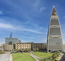 A modern building complex with a prominent tower featuring a unique geometric design.