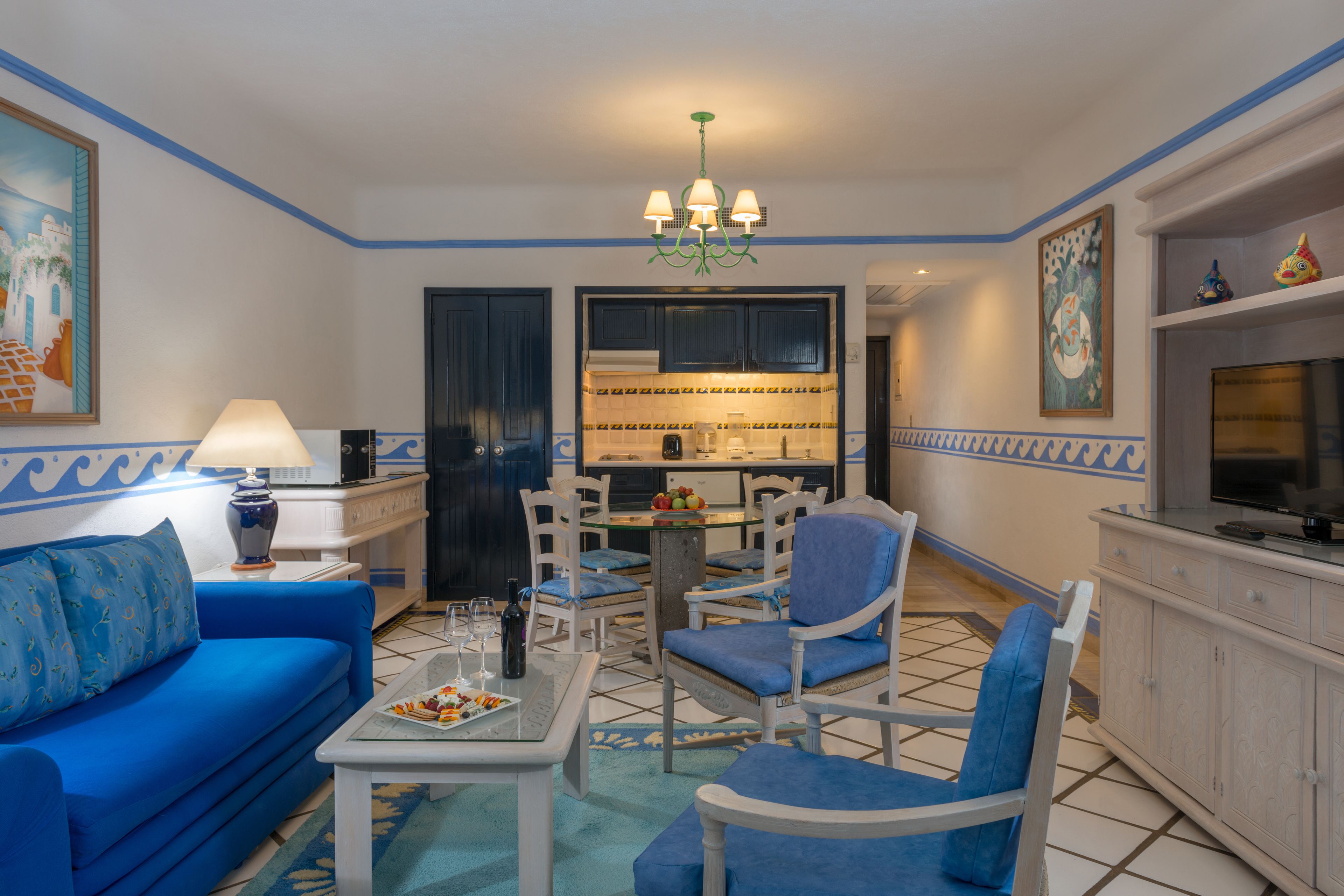 Een woonkamer met een blauwe bank, een salontafel en een eetgedeelte met stoelen en een tafel.