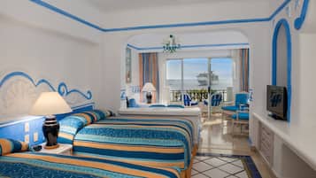 Une chambre d’hôtel avec un grand lit, une télévision et une vue sur la mer.