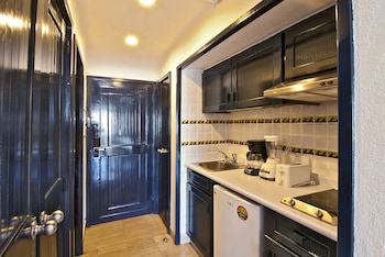 Compact kitchen with oven, sink, and refrigerator, featuring a coffee maker and toaster on the countertop. at Pueblo Bonito Los Cabos Blanco - All Inclusive